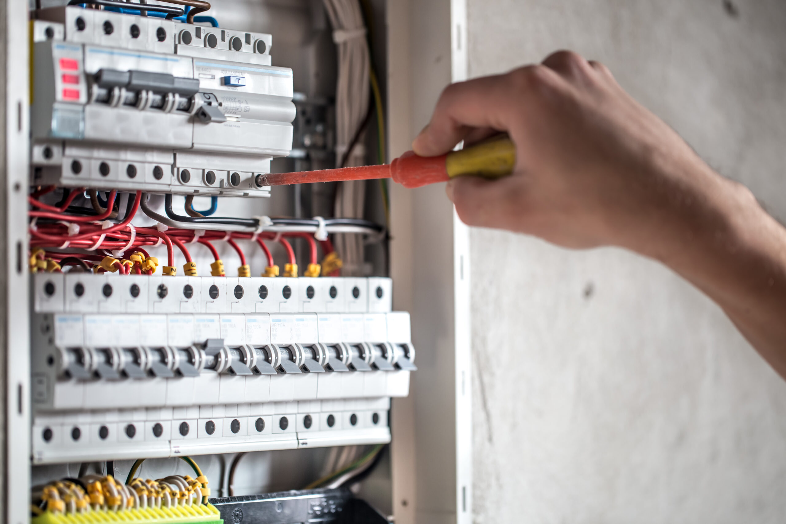 Técnico revisando un tablero eléctrico con interruptores termomagnéticos